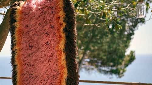 open door with look into room with cement floor that has a rose kelim rug on top of it