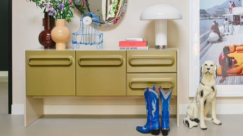 sage green sideboard, dog sculpture and blue boots