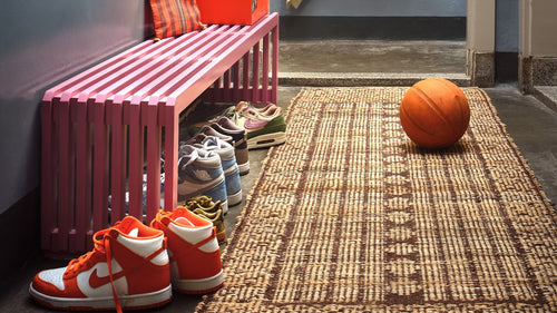 black wooden bench in shaker style against a peach colored wall
