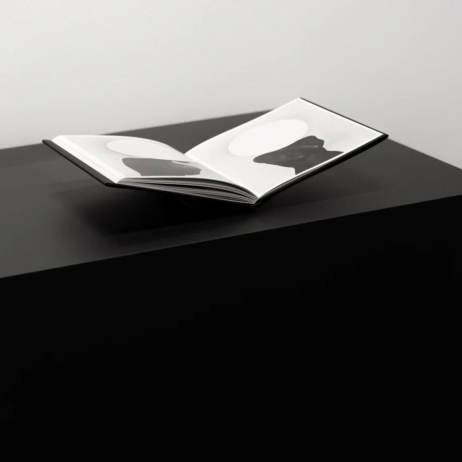 art book on bookstand on a black surface