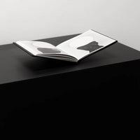art book on bookstand on a black surface