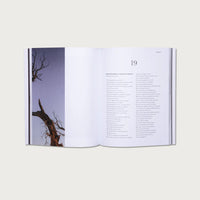 Open book with a page showing a tree silhouette and text on a white background