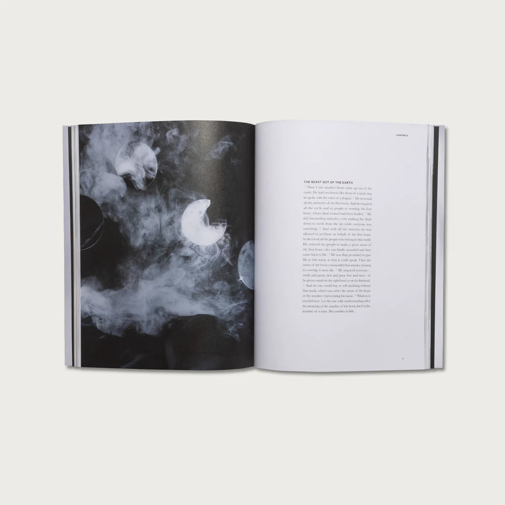 Open book with black and white illustration of a moon and clouds on one page and text on the other, on a light gray background.