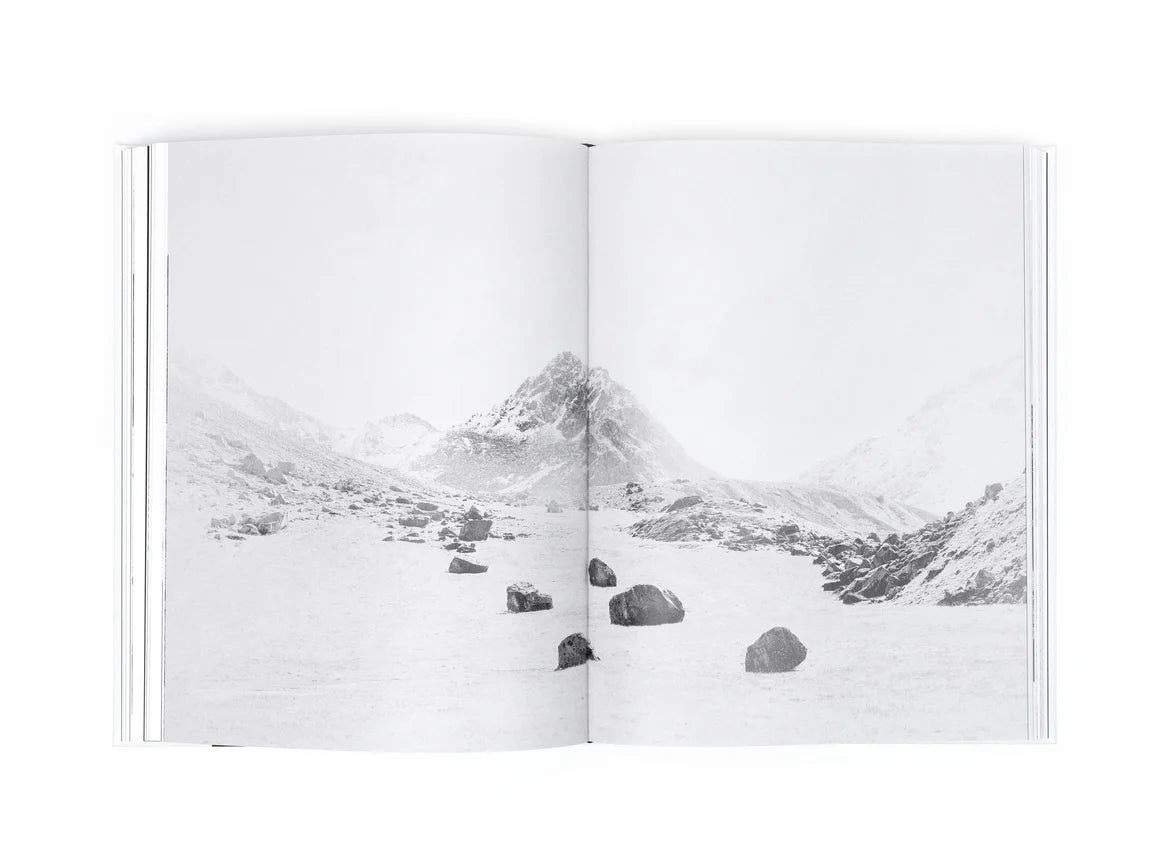 Open book showing a black and white photograph of a mountain landscape.
