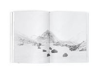 Open book showing a black and white photograph of a mountain landscape.