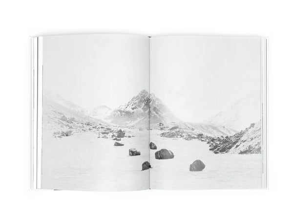 Open book showing a black and white photograph of a mountain landscape.