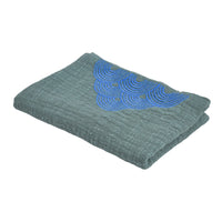 Folded green towel with blue embroidery on a white background
