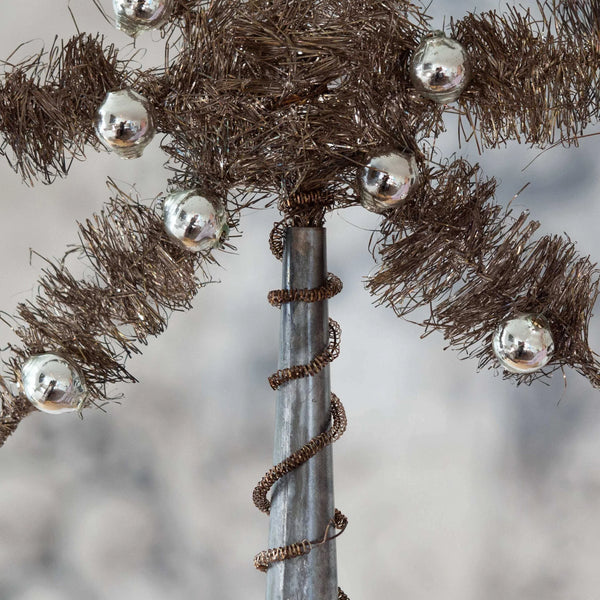 Decorative tinsel with silver beads star Christmas tree topper on a textured background
