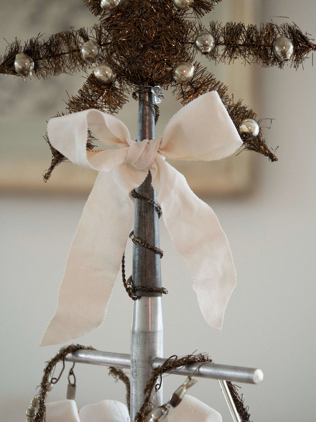 Decorative stand with a white bow and festive elements on a neutral background