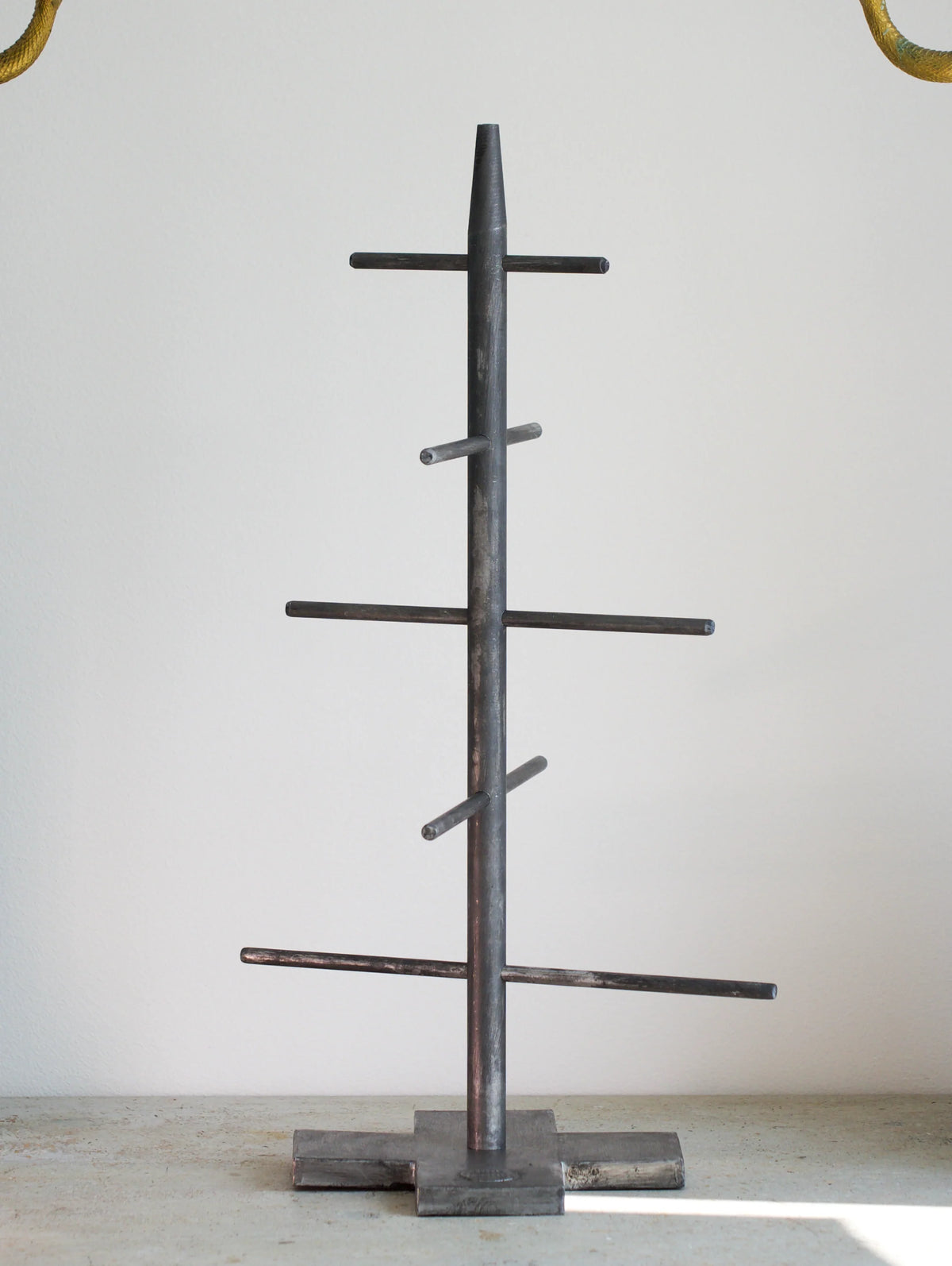 Metal tree-shaped Christmas tree on a light gray background