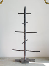 Metal tree-shaped Christmas tree on a light gray background