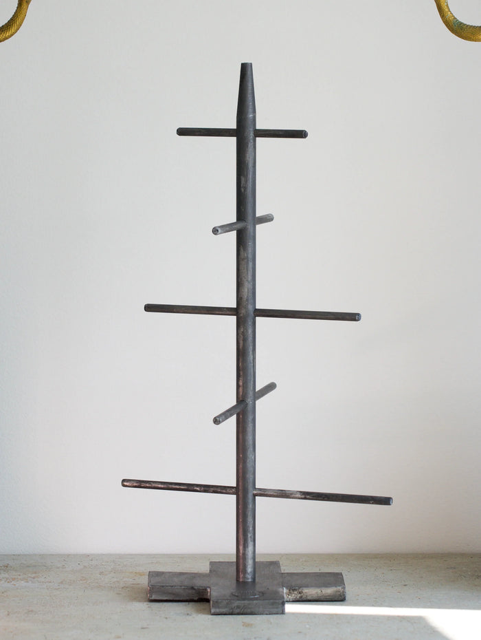 Metal tree-shaped Christmas tree on a light gray background