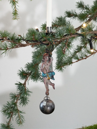 Decorative angel ornament with a silver ball hanging from a Christmas tree branch.