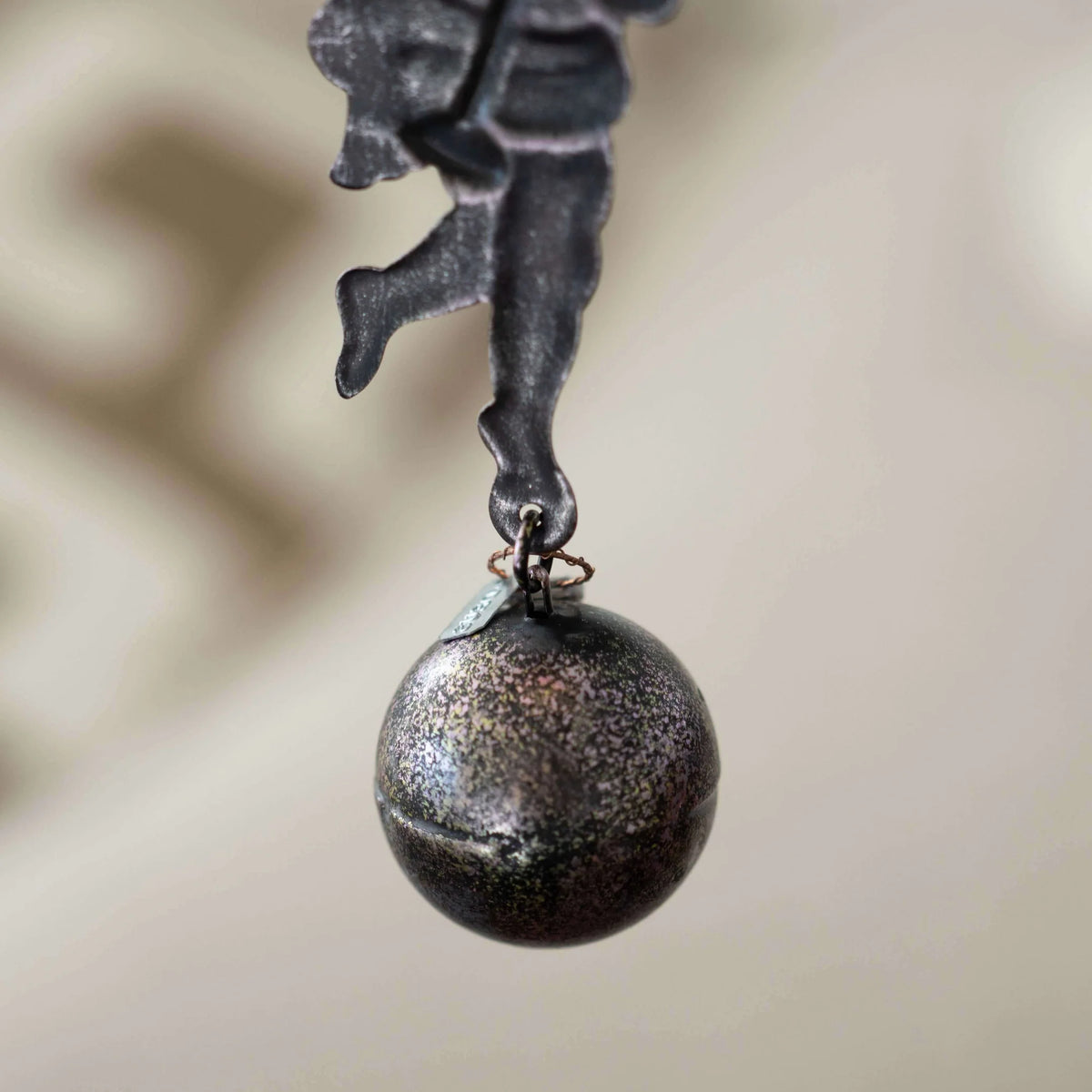 Decorative metal figure with a ball on a blurred background