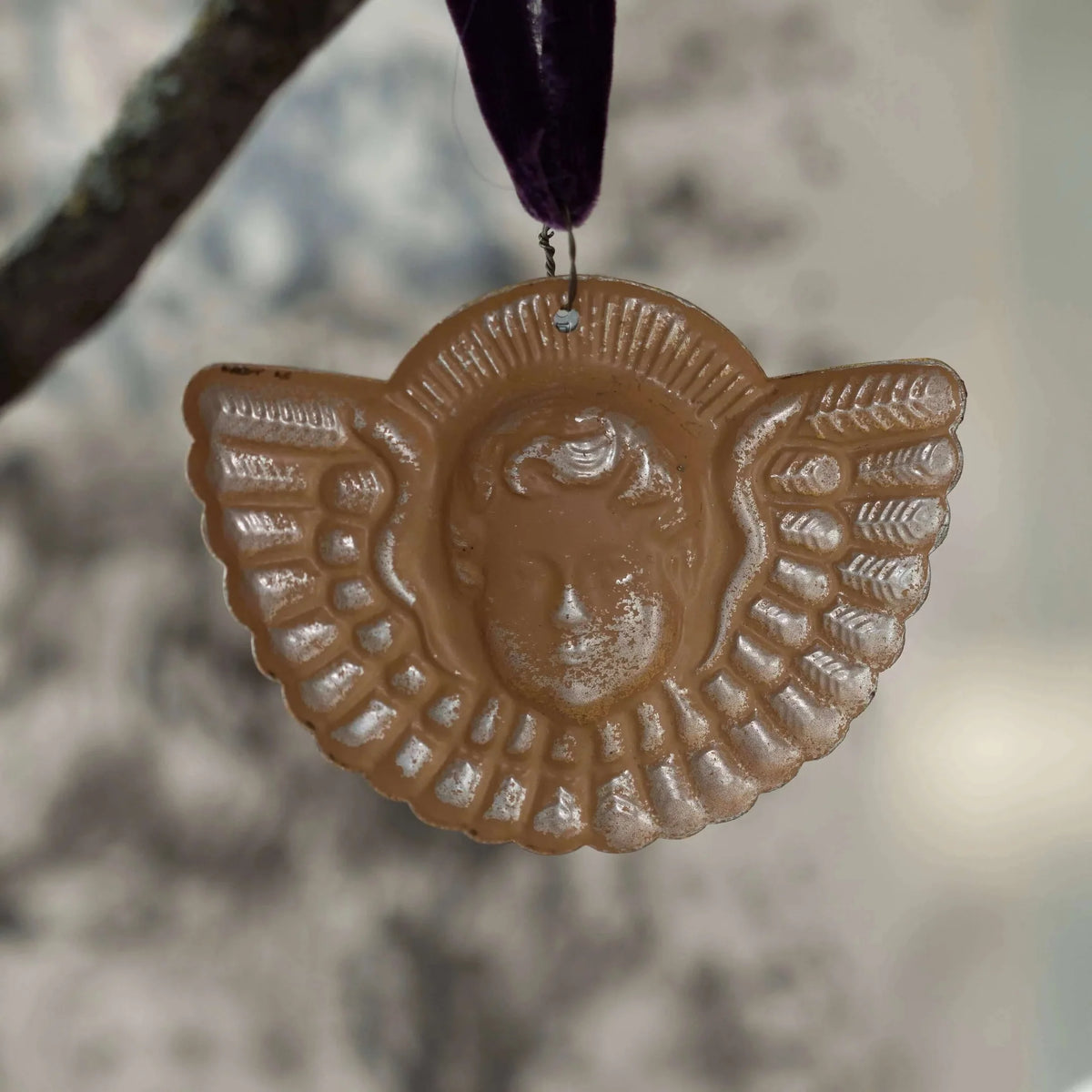 Decorative wall hanging with a face design on a blurred background