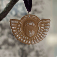 Decorative wall hanging with a face design on a blurred background