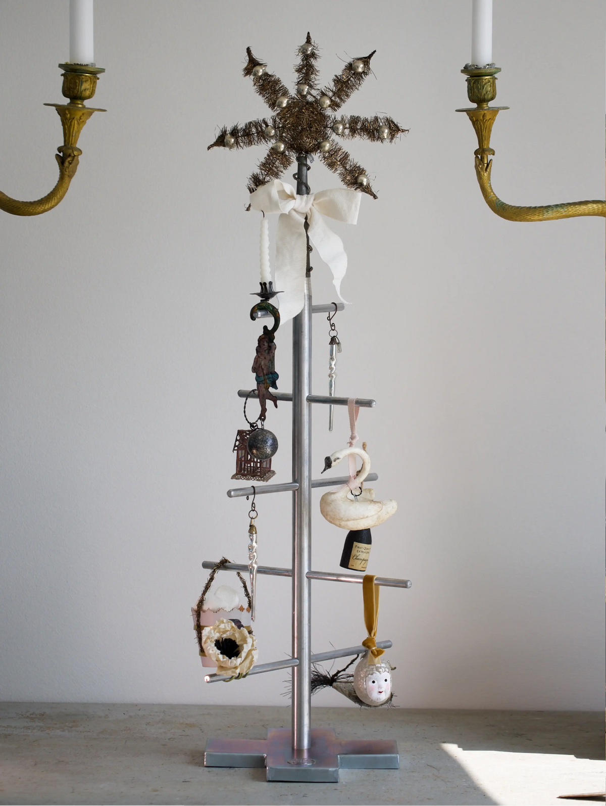 Decorative metal stand with various items against a plain wall