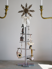 Decorative metal stand with various items against a plain wall