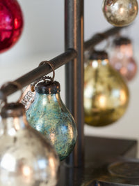 Decorative glass beads on a metal stand with a blurred background