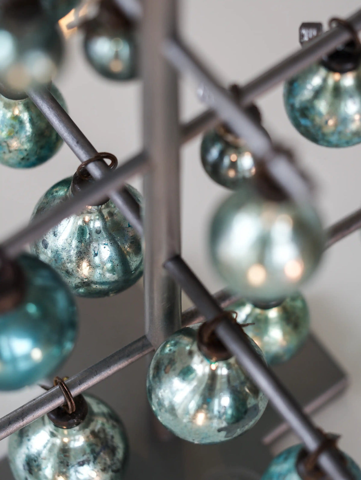Close-up of turquoise glass balls and metal frame.