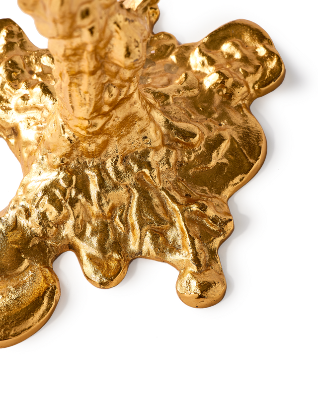 detail of gold colored drip candle stick holder design object