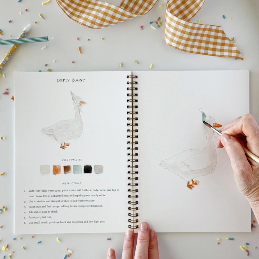 hand holding a brush, coloring a duck with a party hat