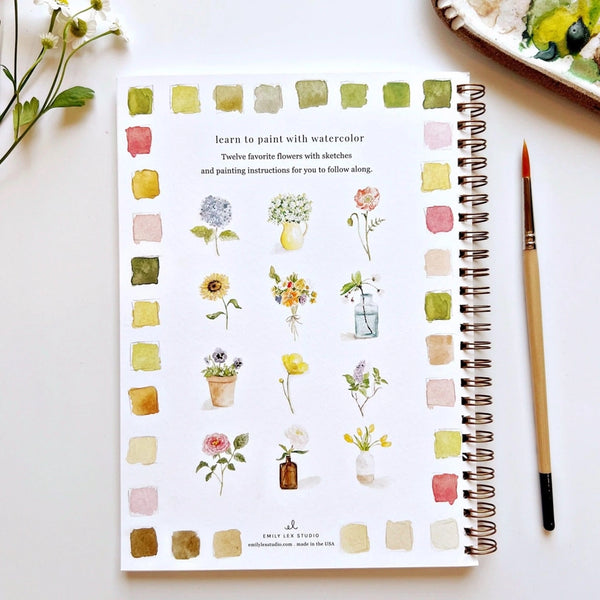 book with flowers and water color samples and paint brush