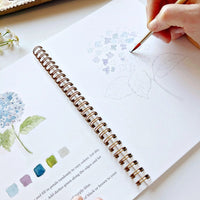watercolor book with hand and painting