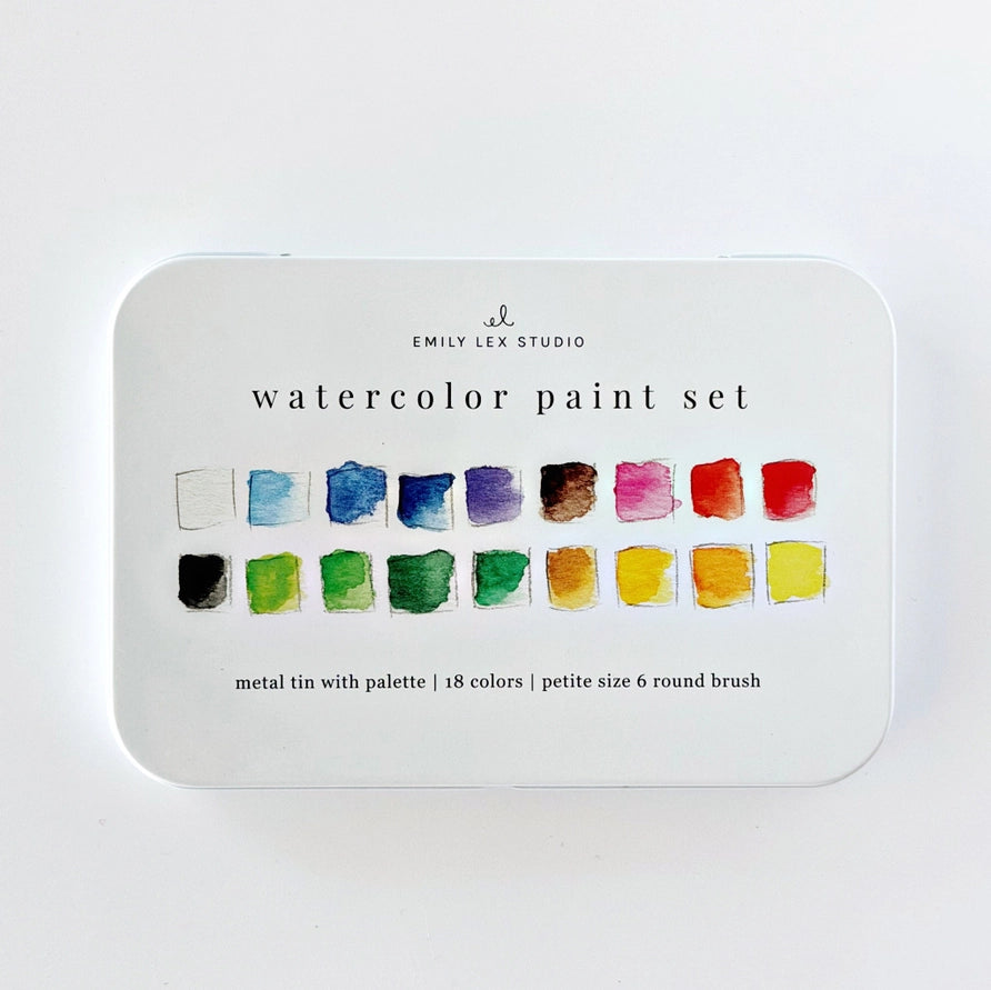 A metal tin of Emily Lex Studio watercolor paint set, featuring a white lid with 18 watercolor swatches in various colors and black text detailing the contents.