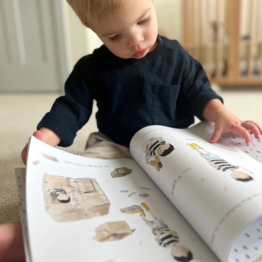Child looking at a book with illustrations of children