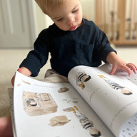 Child looking at a book with illustrations of children
