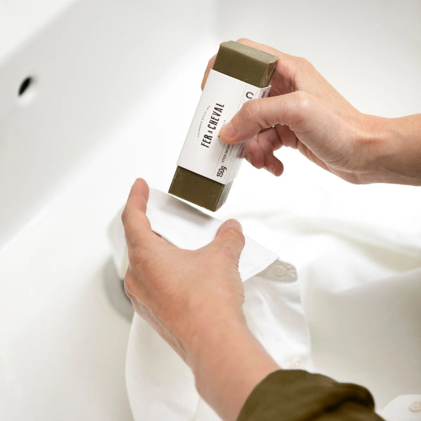 stain remover soap stick  two hands and shirt