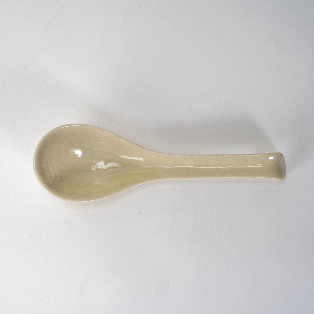 Beige ceramic spoon on a white background