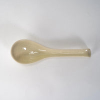 Beige ceramic spoon on a white background
