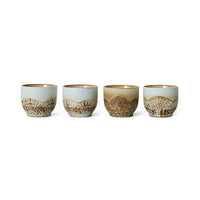 Set of four ceramic cups with a textured design on a white background