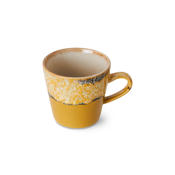 Yellow ceramic mug with speckled pattern on a white background