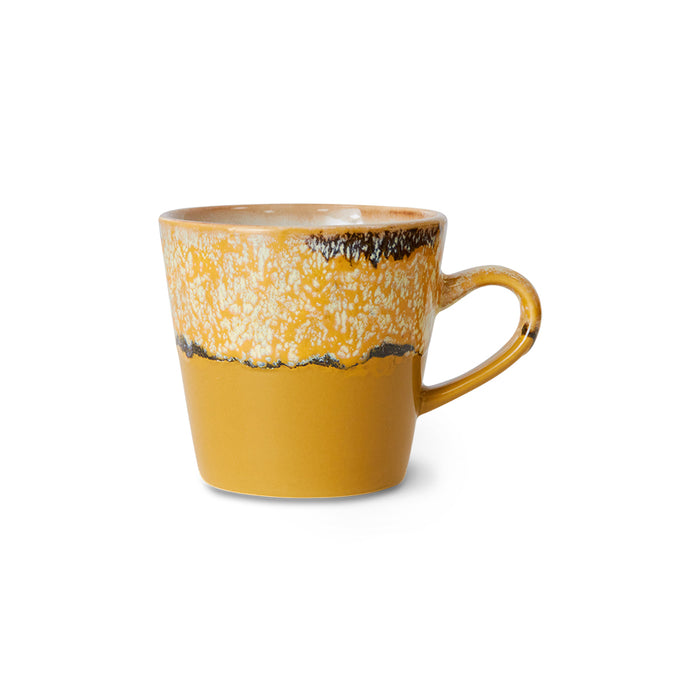 Yellow ceramic mug with speckled pattern on a white background