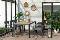 Outdoor dining area with a table and chairs on a wooden deck.