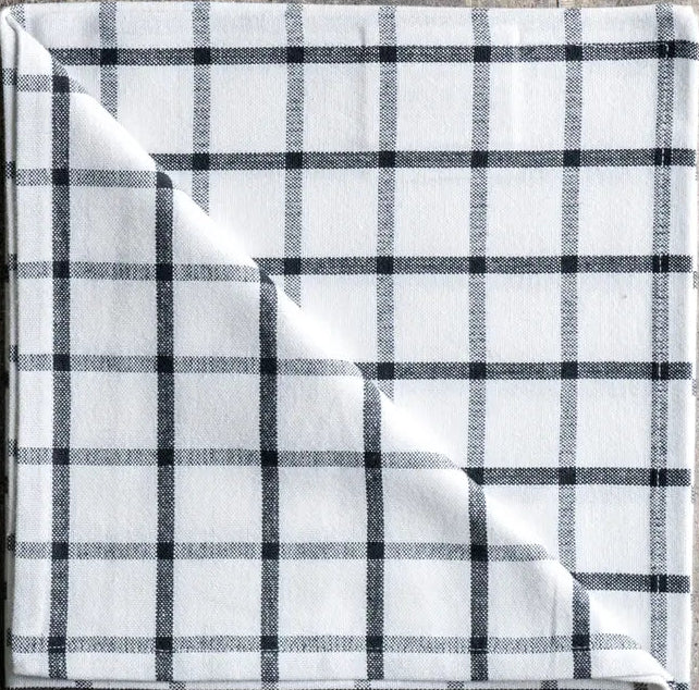 Plaid fabric with black and white pattern on a wooden surface