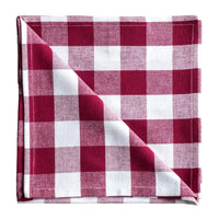 Folded red and white checkered fabric  napkin on a white surface