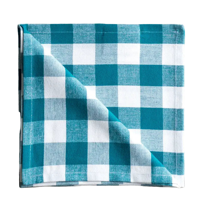 Folded blue and white checkered fabric napkin on a white surface