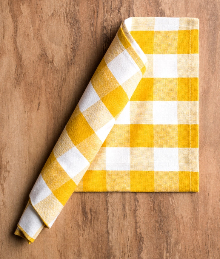 Yellow and white checkered towel on a wooden surface