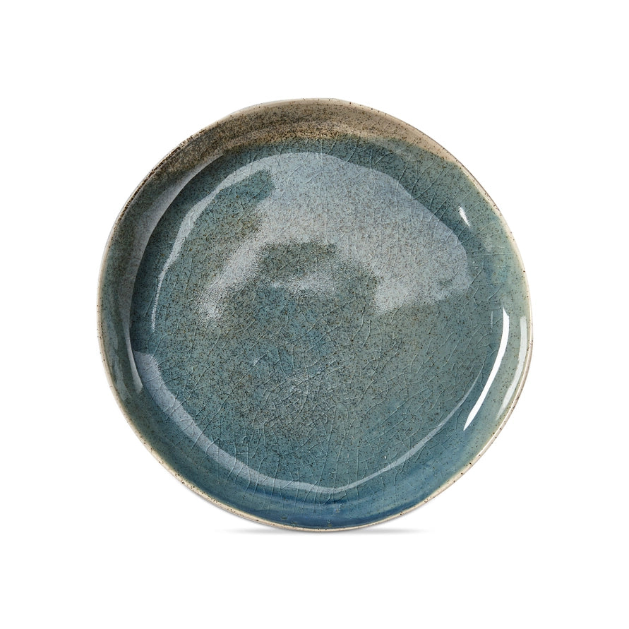 Blue, reactive glaze organic shaped round salad plate on a white background