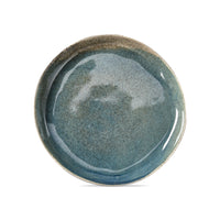 Blue, reactive glaze organic shaped round salad plate on a white background
