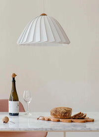 metal corkscrew with a Nordic style wooden head of bird on a marble table with bottle of wine and sliced bread
