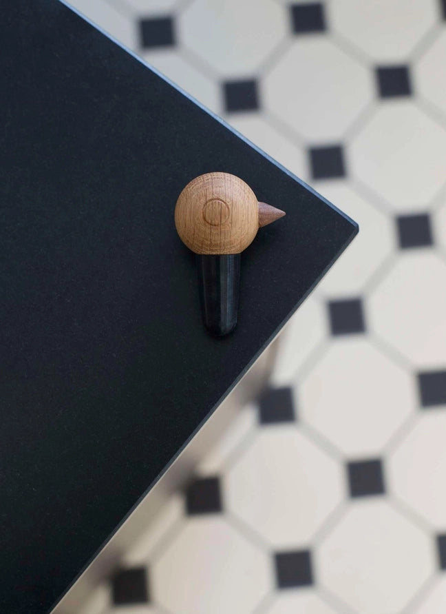 wine stopper with Nordic look made from wood and natural rubber on a black surface