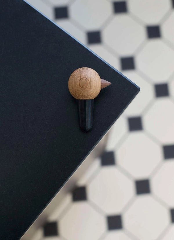 wine stopper with Nordic look made from wood and natural rubber on a black surface