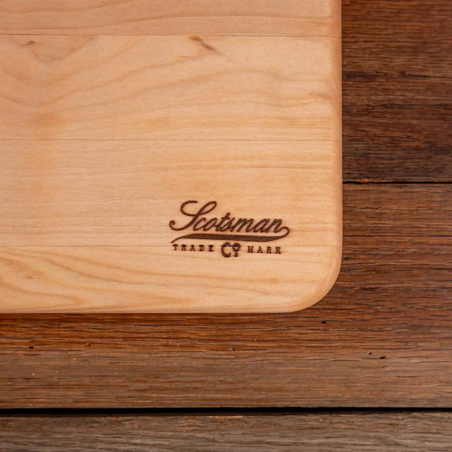 Wooden cutting board with 'Scotsman' branding on a wooden surface