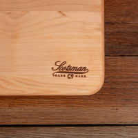 Wooden cutting board with 'Scotsman' branding on a wooden surface