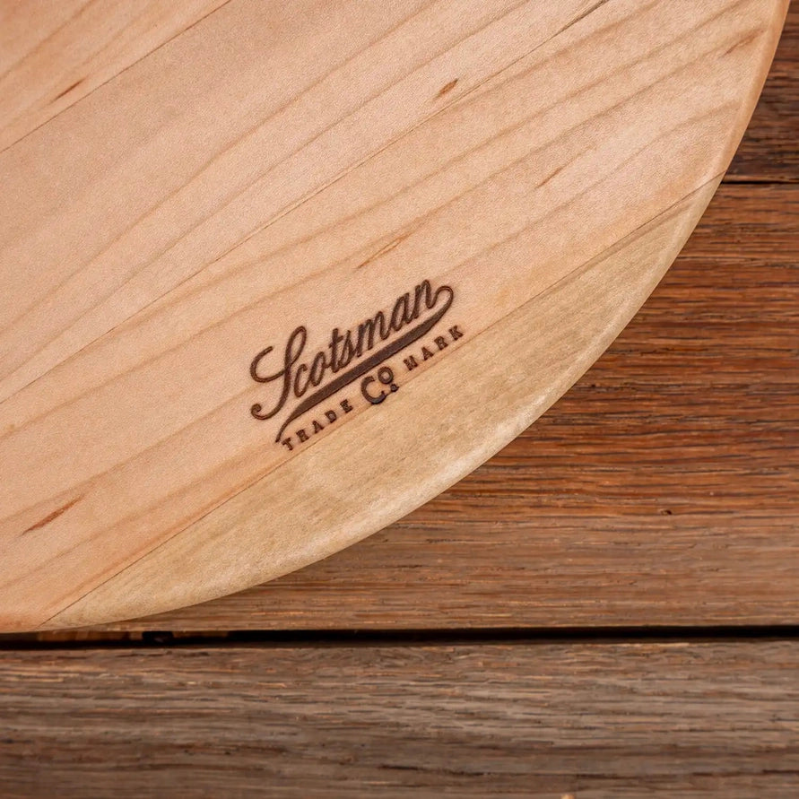 Wooden cutting board with 'Scotsman' branding on a wooden surface